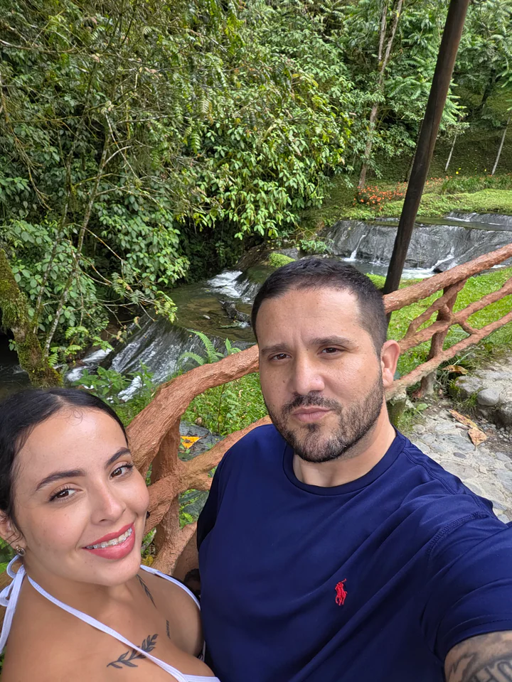 Maira y Alejandro juntos frente a un arroyo y árboles