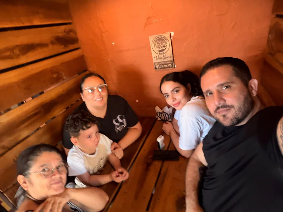 Maira y Alejandro con un grupo de personas, incluido un niño, alrededor de una mesa